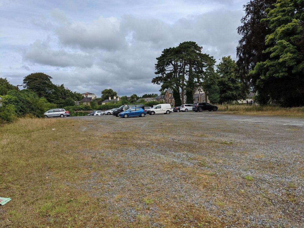 Large gravel car park on Leinster Street with plenty of empty spaces