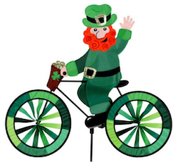 Cartoon leprechaun in green riding a shamrock-decorated bicycle for St. Patrick’s Day
