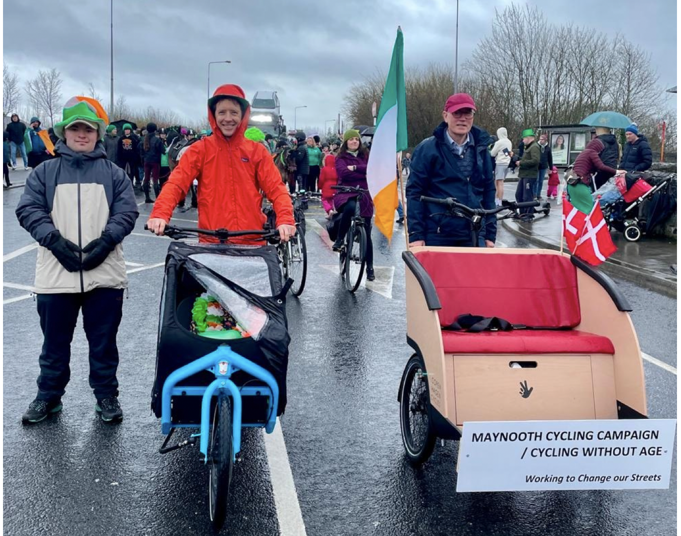 MCC members pose with a blue cargo bike and the Cycling Without Age trishaw signed ‘Maynooth Cycling Campaign’